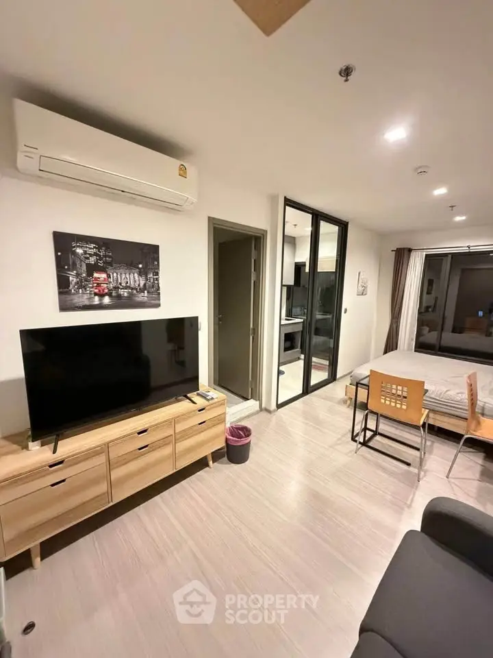 Modern living room with TV, air conditioning, and stylish decor in a cozy apartment.
