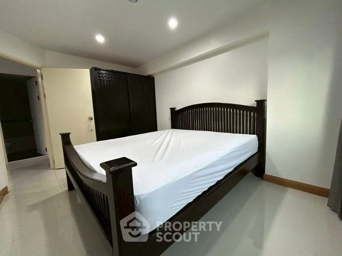 Spacious bedroom with elegant wooden bed and ample closet space.