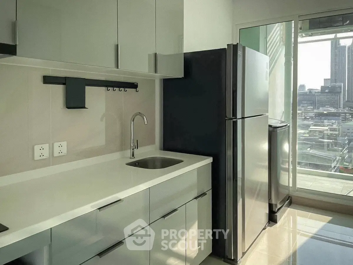 Modern kitchen with sleek cabinets and city view from window
