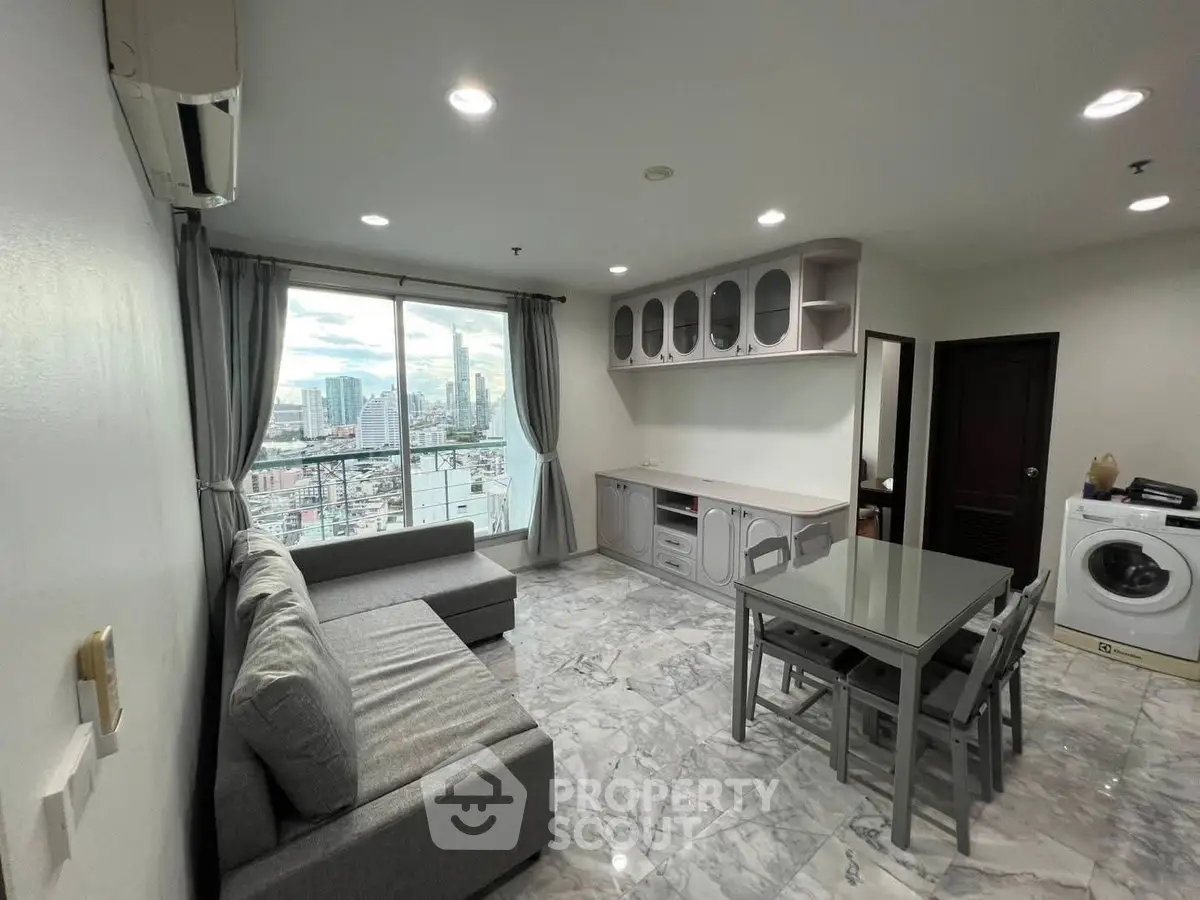 Modern living room with city view, featuring sleek furniture and marble flooring.