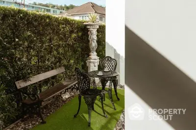 Charming garden patio with vintage metal furniture and lush greenery