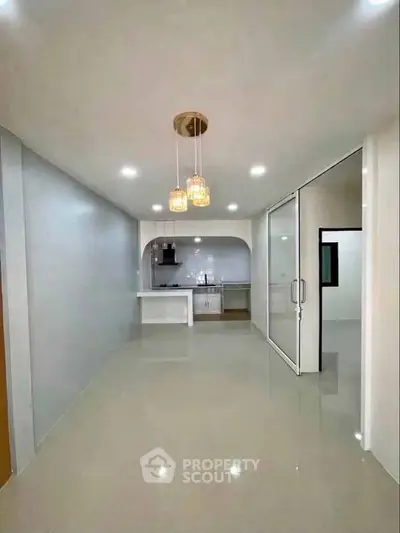 Modern open-layout kitchen with sleek lighting and spacious design, perfect for contemporary living.