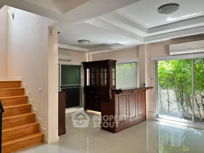 Spacious living area with elegant wooden furniture and large windows