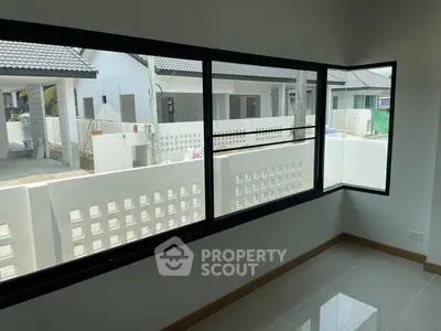 Modern interior with large windows overlooking a residential neighborhood.