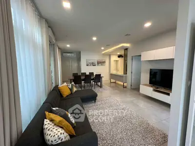 Spacious modern living room with elegant decor and open dining area, perfect for entertaining.
