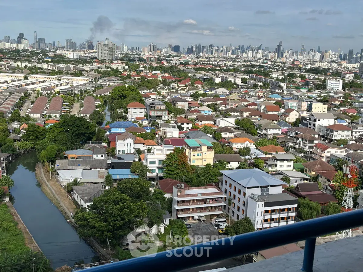 Stunning cityscape view from high-rise balcony overlooking urban landscape and canal.