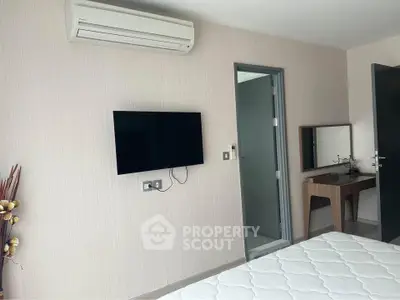 Modern bedroom with wall-mounted TV and air conditioning unit, featuring a minimalist design.