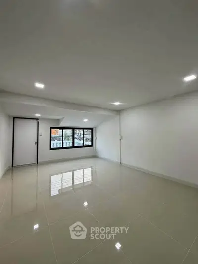 Spacious unfurnished room with large windows and glossy tiled floor, perfect for customization.
