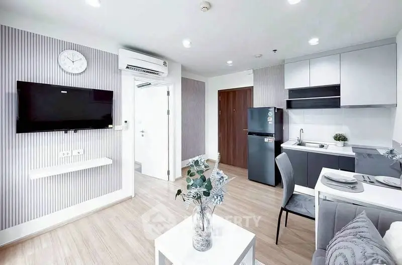 Modern open-layout living room with sleek kitchen in stylish apartment