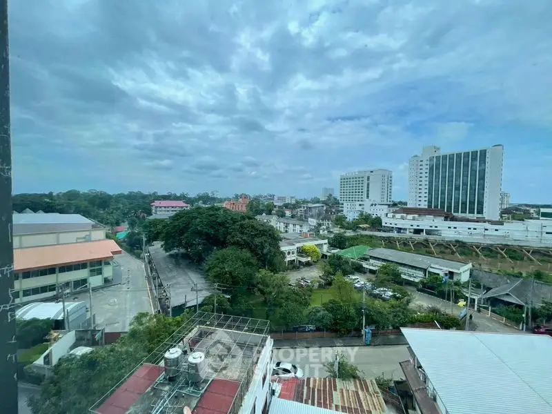 Stunning cityscape view from high-rise building window, showcasing urban landscape and greenery.