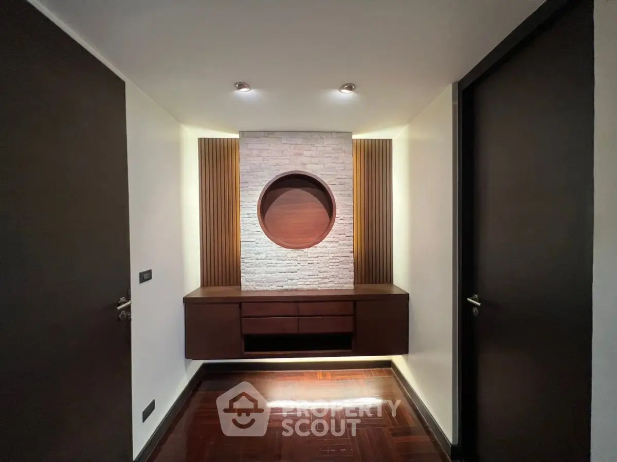 Modern hallway with elegant wood paneling and unique circular wall feature.