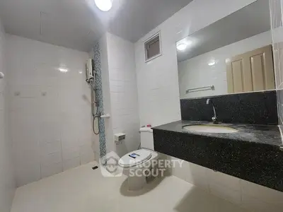 Spacious modern bathroom with sleek fixtures and large mirror in a contemporary home.