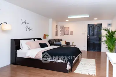 Spacious modern bedroom with elegant decor and cozy seating area, perfect for relaxation.