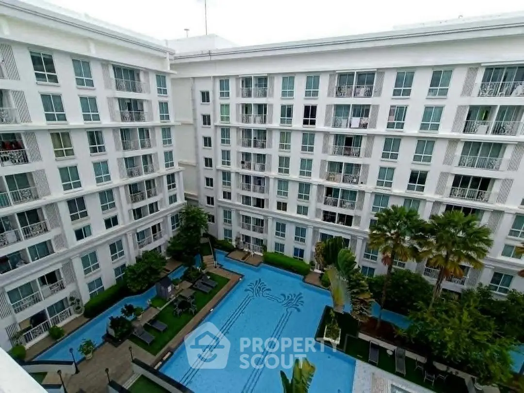 Luxurious apartment complex with stunning pool and lush greenery, perfect for modern living.