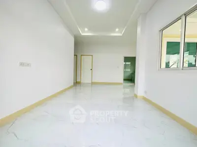 Spacious and bright interior with modern white marble flooring and recessed lighting.