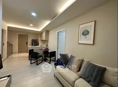 Modern living room with open kitchen, stylish decor, and cozy seating area.