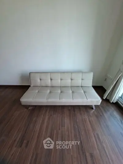 Minimalist living room with modern beige sofa and wooden flooring