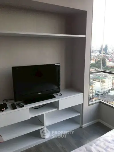 Modern living room with built-in TV unit and city view from window