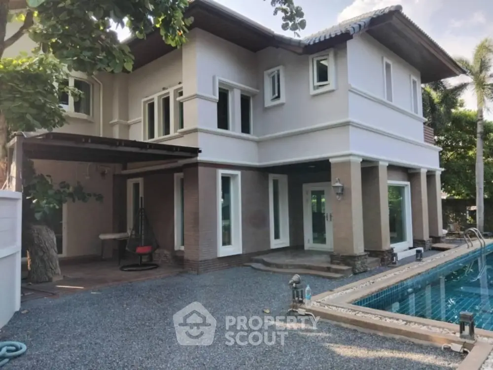 Stunning two-story house with pool and lush greenery, perfect for luxury living.
