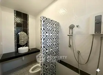 Stylish bathroom with modern fixtures and elegant black and white tile design.