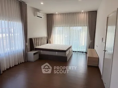 Spacious bedroom with modern design and large windows for natural light.