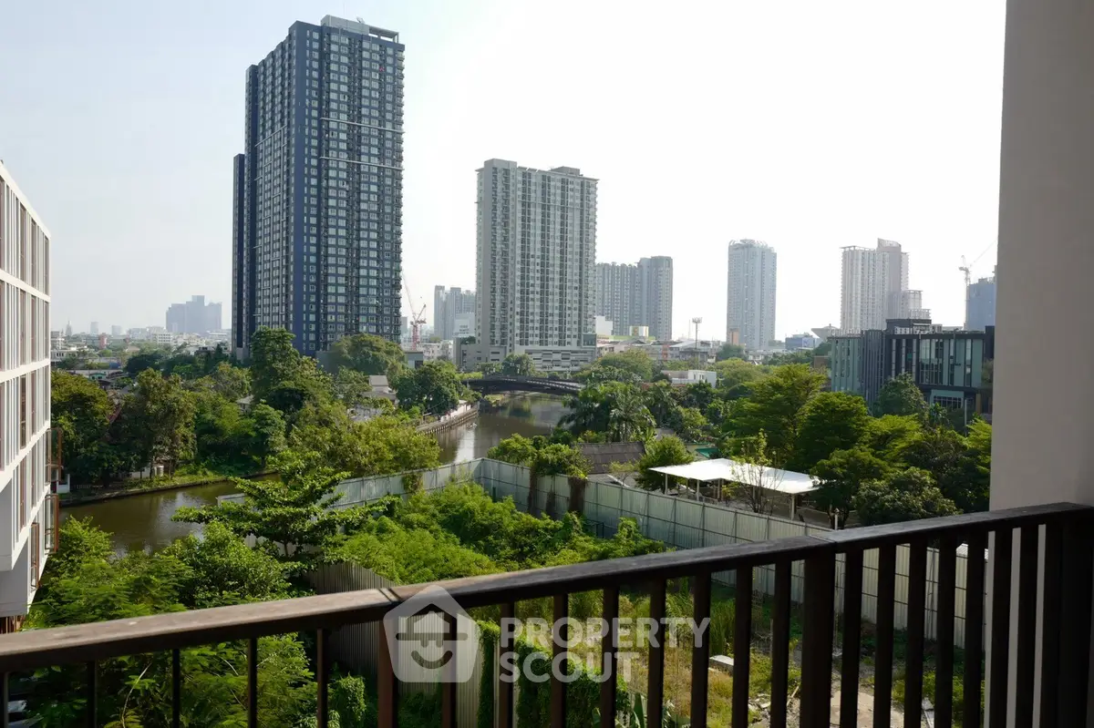 Stunning cityscape view from a high-rise balcony overlooking lush greenery and modern skyscrapers.