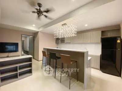 Modern kitchen with sleek design, featuring a marble island and stylish lighting, perfect for entertaining.