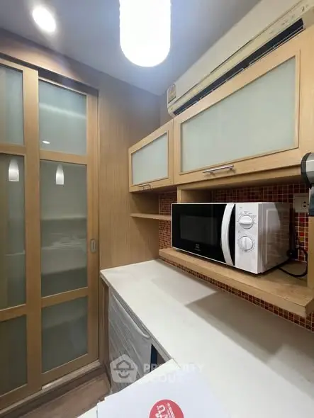 Compact kitchen with microwave and sliding glass cabinets