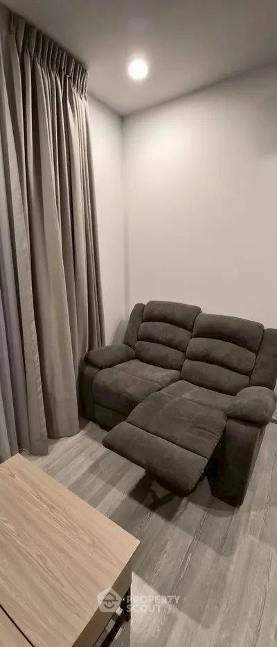 Cozy living room with plush recliner and elegant curtains