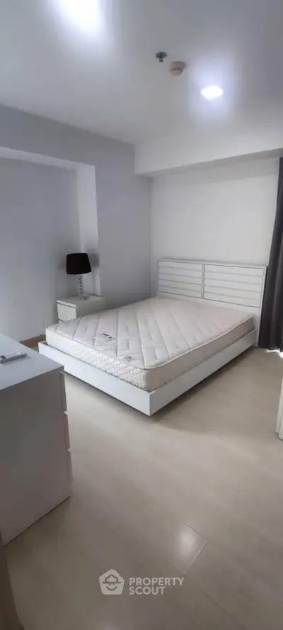 Modern minimalist bedroom with white furniture and natural light