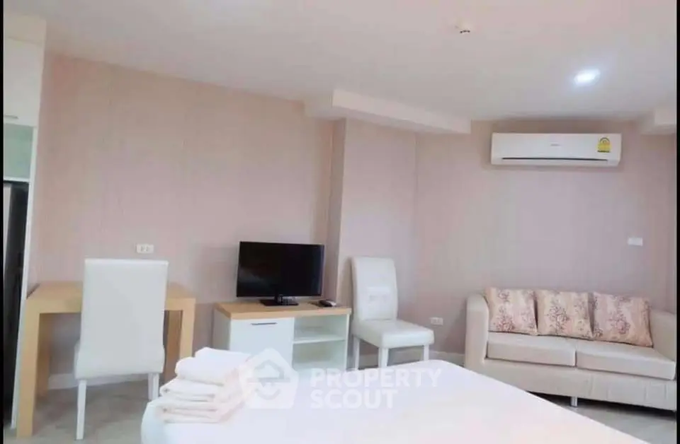 Modern living room with cozy sofa, TV, and air conditioning in a stylish apartment.