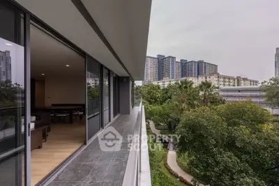 Spacious balcony with city view and lush greenery, perfect for relaxation and enjoying urban living.