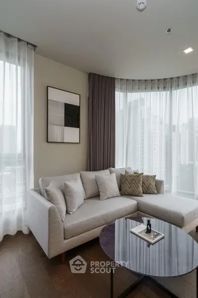 Modern living room with stylish corner sofa and city view through large windows.