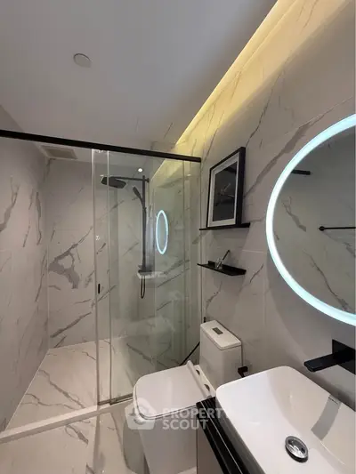 Luxurious modern bathroom with marble tiles and sleek shower design.