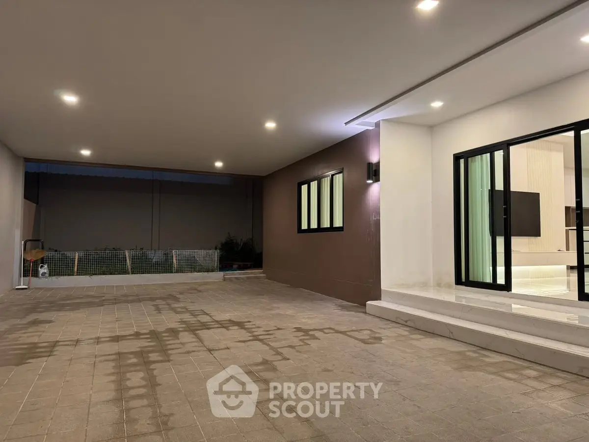 Spacious modern covered parking area with sleek lighting and large windows.