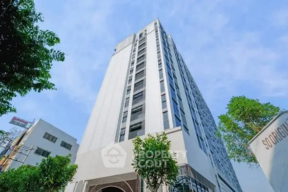 Modern high-rise building with sleek design and lush greenery