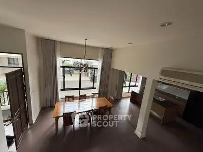 Spacious dining area with large windows and modern decor in a stylish home.