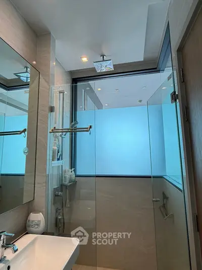 Modern bathroom with glass shower enclosure and sleek fixtures