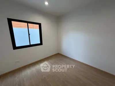 Minimalist empty room with wooden flooring and large window