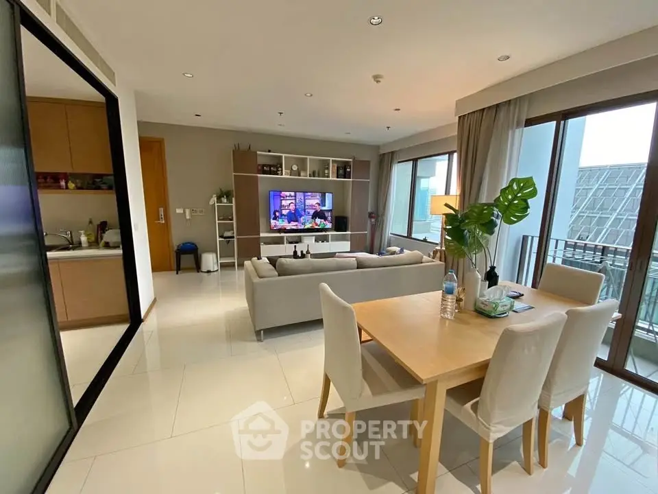 Modern living room with dining area and balcony view in a stylish apartment.