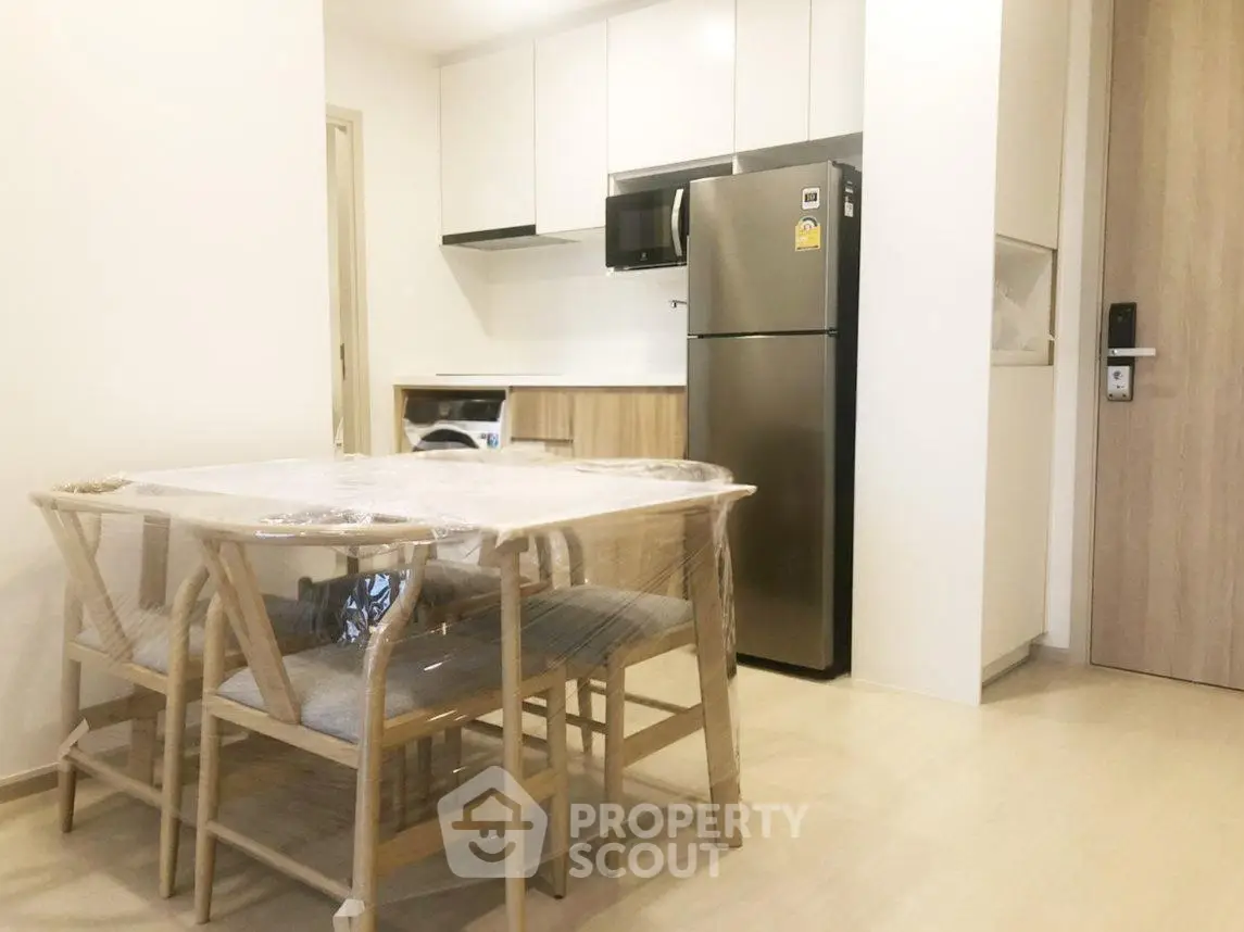 Modern kitchen with dining area featuring sleek appliances and minimalist design.