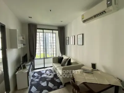 Modern living room with balcony view, stylish decor, and air conditioning in urban apartment.