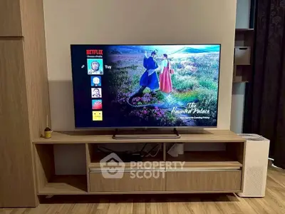 Modern living room with sleek wooden TV stand and large flat-screen TV displaying Netflix interface.