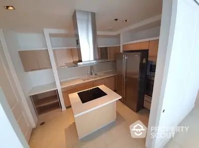 Modern kitchen with island and stainless steel appliances in luxury apartment