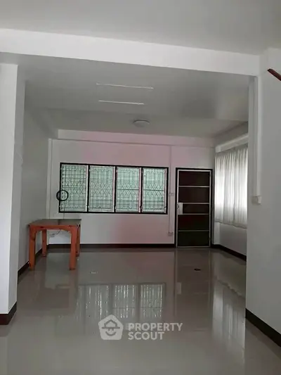 Spacious unfurnished room with large windows and glossy tiled floor