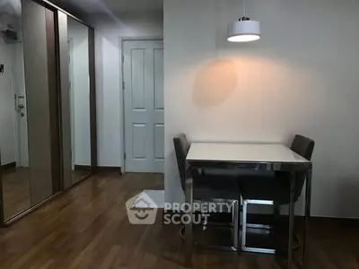 Modern dining area with sleek table and chairs, wooden flooring, and ambient lighting.