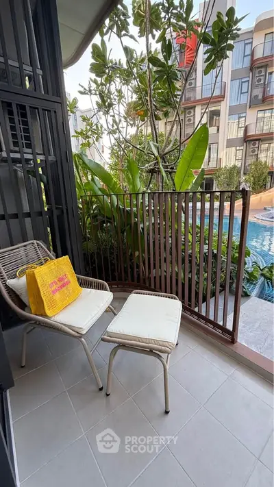 Charming balcony with pool view in modern apartment complex, perfect for relaxation and leisure.