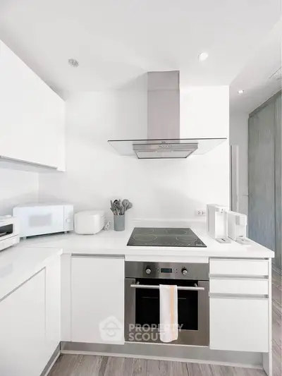 Modern kitchen with sleek white cabinetry and built-in oven