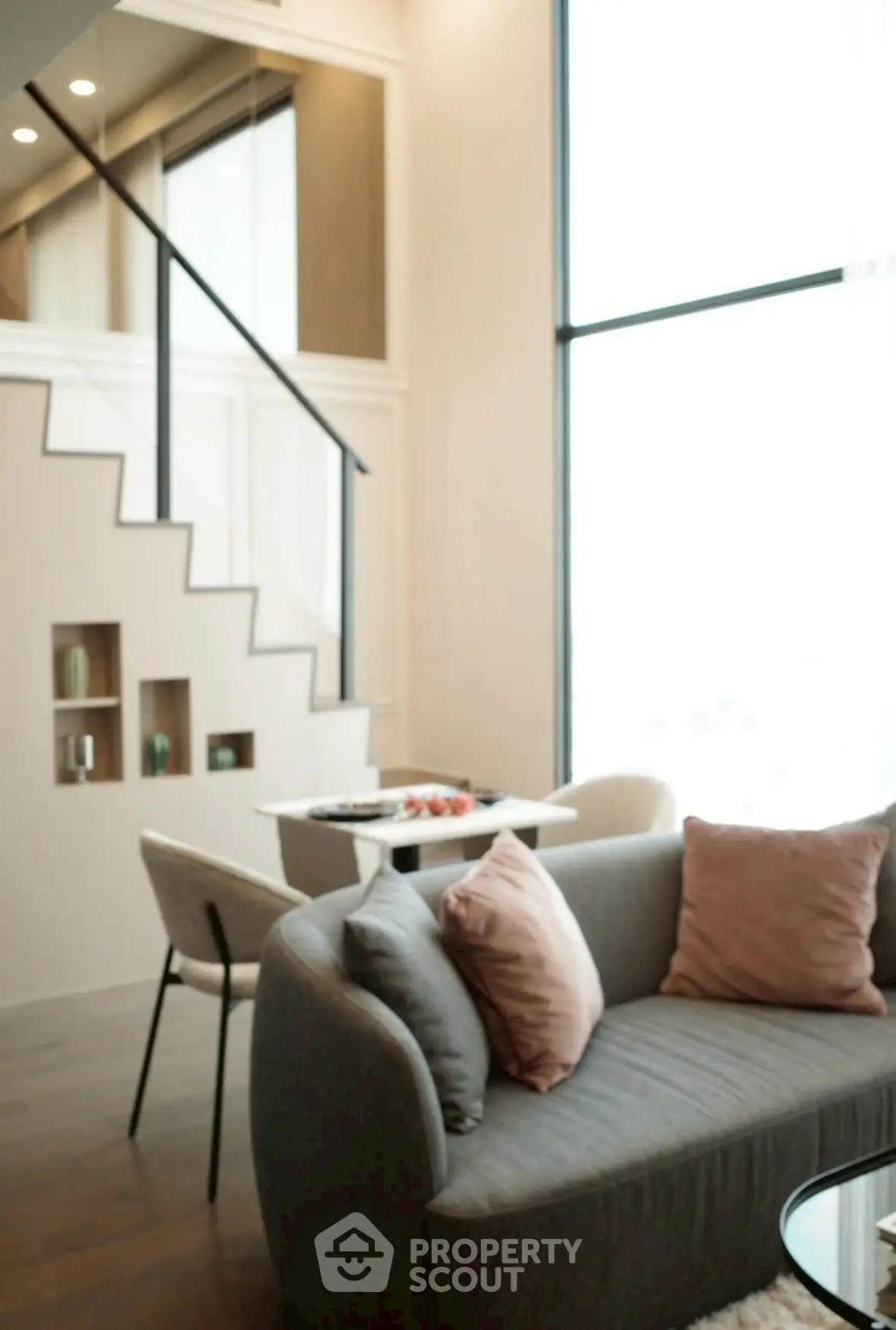 Modern living room with high ceilings and stylish staircase in a luxury apartment.