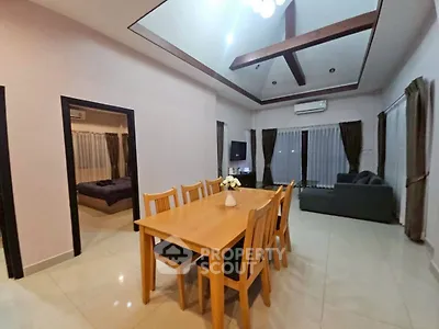 Spacious living and dining area with high ceiling and modern decor